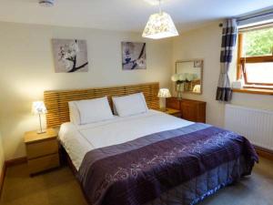 a bedroom with a large bed and a window at Poppy Cottage in Lancaster