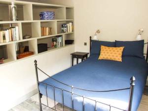 a bedroom with a blue bed and shelves at The Stable in Ross on Wye