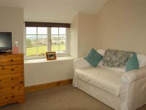 a living room with a couch and a window at Ty Cerrig in Mold