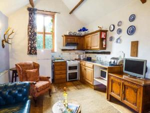 a kitchen with a refrigerator and a table with a couch at The Mill in Bicknoller