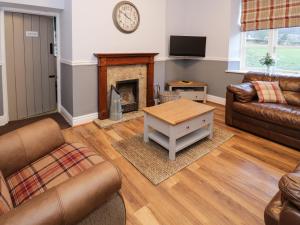 a living room with a couch and a fireplace at The Farm House in Llangollen