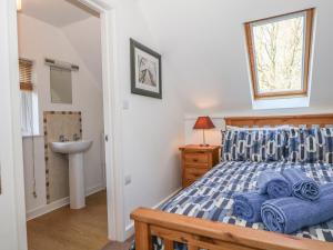 ein Schlafzimmer mit einem Bett, einem Waschbecken und einem Fenster in der Unterkunft The Roost in Broughton