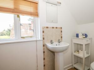 a white bathroom with a sink and a window at The Roost in Broughton