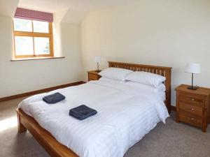 LlangwmにあるTy Gwynのベッドルーム1室(白いベッド1台、タオル2枚付)