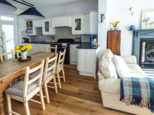 a kitchen with a couch and a table with chairs at Rose Cottage in Cardigan
