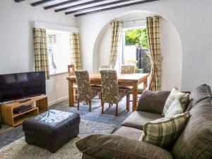 a living room with a couch and a dining room table at The Nook in Windermere