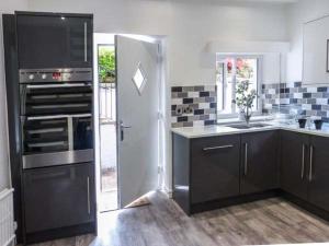 a kitchen with a stove and a sink and a refrigerator at The Nook in Windermere