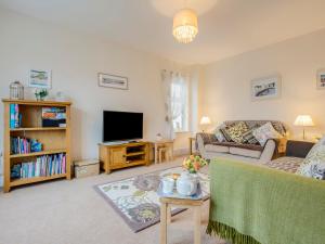 a living room with a couch and a tv at Woodside in Bideford
