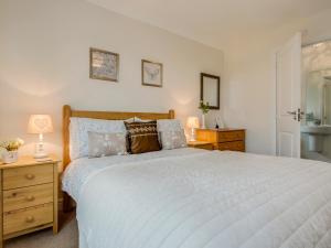 a bedroom with a large bed and a bathroom at Woodside in Bideford