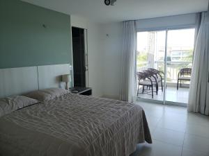 ein Schlafzimmer mit Bett und Blick auf einen Balkon in der Unterkunft Apto Completo l Excelente Vista em Golf Ville Resort in Aquiraz + 65 Fotos