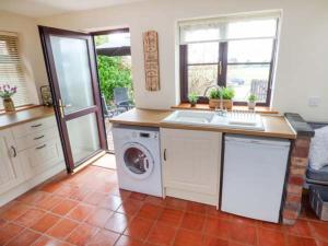 a kitchen with a sink and a washing machine at Beacon Cottage in Great Malvern