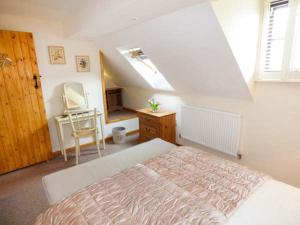 a bedroom with a bed and a dresser and a window at Beacon Cottage in Great Malvern