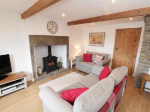 a living room with a couch and a fireplace at Bramble Cottage in Holmfirth