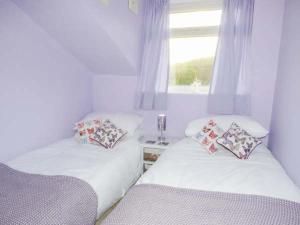 two twin beds in a room with a window at Chapel Cottage in Whitby