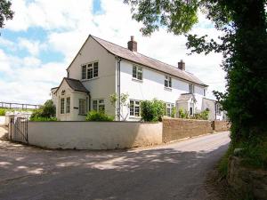 a large white house sitting on the side of a road at The Old Smithy in Bridport