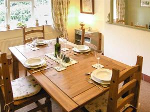 a wooden table with plates and a bottle of wine at The Old Smithy in Bridport