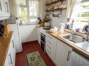 a kitchen with a sink and a stove at The Old Smithy in Bridport +12 photos