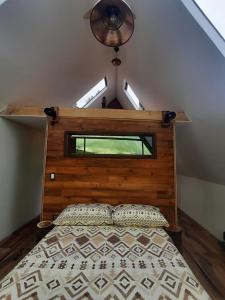 a bedroom with a bed with a wooden headboard at Cabaña Santo Domingo in Cuítiva