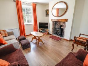 a living room with a couch and a fireplace at Marsh Cottage in South Molton
