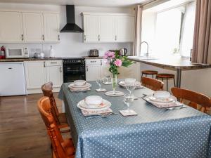 uma cozinha com uma mesa com uma toalha de mesa azul e branca em Marsh Cottage em South Molton