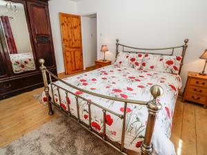 um quarto com uma cama com colcha floral em Marsh Cottage em South Molton