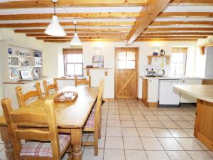 a kitchen and dining room with a wooden table and chairs at Snowdon View in Holyhead