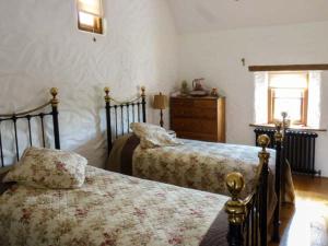 sypialnia z 2 łóżkami i komodą w obiekcie Annie's Cottage w mieście Clogher