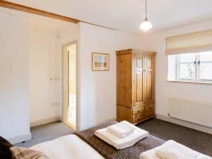 a bedroom with two beds and a wooden cabinet at The Hayloft in Kendal