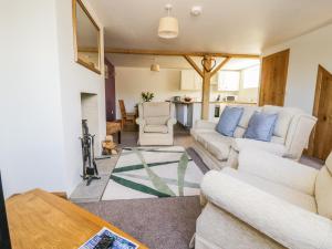 a living room with two white couches and a table at Swan Cottage in Fearby