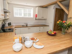 una cucina con tavolo in legno e cibo di Swan Cottage a Fearby