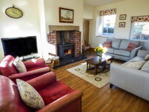 a living room with two couches and a fireplace at Old Hall Cottage in Settle