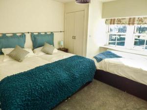 a large bedroom with two beds and a window at Old Hall Cottage in Settle