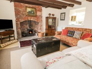 a living room with a brick fireplace and couches at The Lookout in Tweedmouth