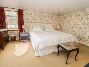 um quarto com uma cama grande e papel de parede floral em The Lookout em Tweedmouth
