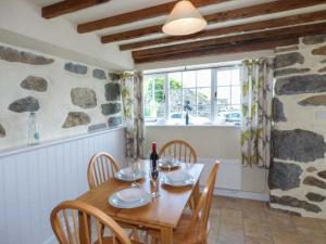 a dining room with a wooden table and chairs at Y Stabal in Chwilog