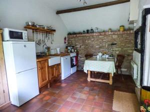 a kitchen with a table and a white refrigerator at The Smithy in Leominster
