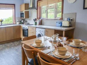 a kitchen with a wooden table with chairs and a dining room at Fisherman's Cottage in Ullapool