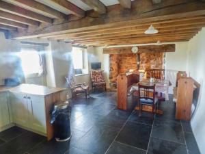 a living room with a table and a dining room at Tyn Llwyn in Dolgellau