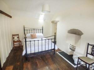 a bedroom with a bed and two chairs in it at Tyn Llwyn in Dolgellau