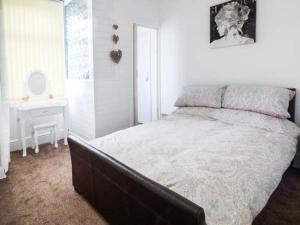 a bedroom with a large bed and a table at Flat 2 in Bridlington
