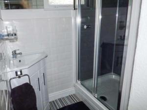 a white bathroom with a shower and a sink at Flat 2 in Bridlington