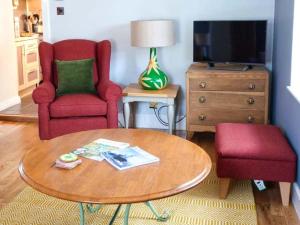 salon ze stołem, 2 krzesłami i telewizorem w obiekcie Grace Cottage w mieście Buckie