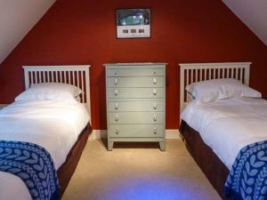 a bedroom with two twin beds and a dresser at Grace Cottage in Buckie