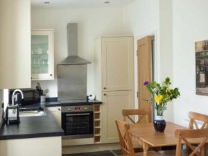 een keuken met een tafel en een fornuis top oven bij Loughrigg View in Ambleside