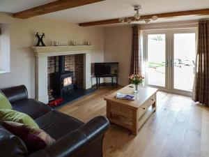 a living room with a couch and a fireplace at Rose Cottage in Winforton