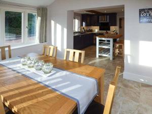 Winforton的住宿－Rose Cottage，厨房以及带木桌和椅子的用餐室