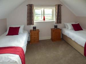 ein Schlafzimmer mit zwei Einzelbetten und einem Fenster in der Unterkunft Rose Cottage in Winforton