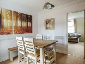 a dining room with a wooden table and chairs at Fern Cottage in Heacham