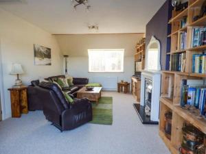 a living room with a couch and a fireplace at Glan Y Mor in Amlwch