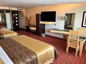 ein Hotelzimmer mit zwei Betten und einem Flachbildfernseher in der Unterkunft Hotel Scala Magna in Mexiko-Stadt